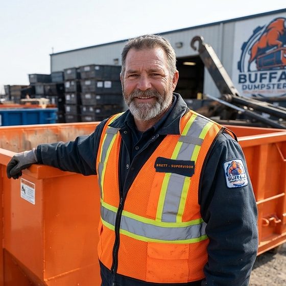 Brett, Buffalo Dumpster Co. yard supervisor, beside an orange roll-off container at the yard